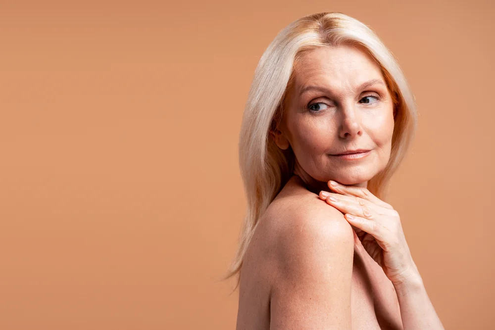 Retrato editorial de una mujer madura sobre fondo cálido