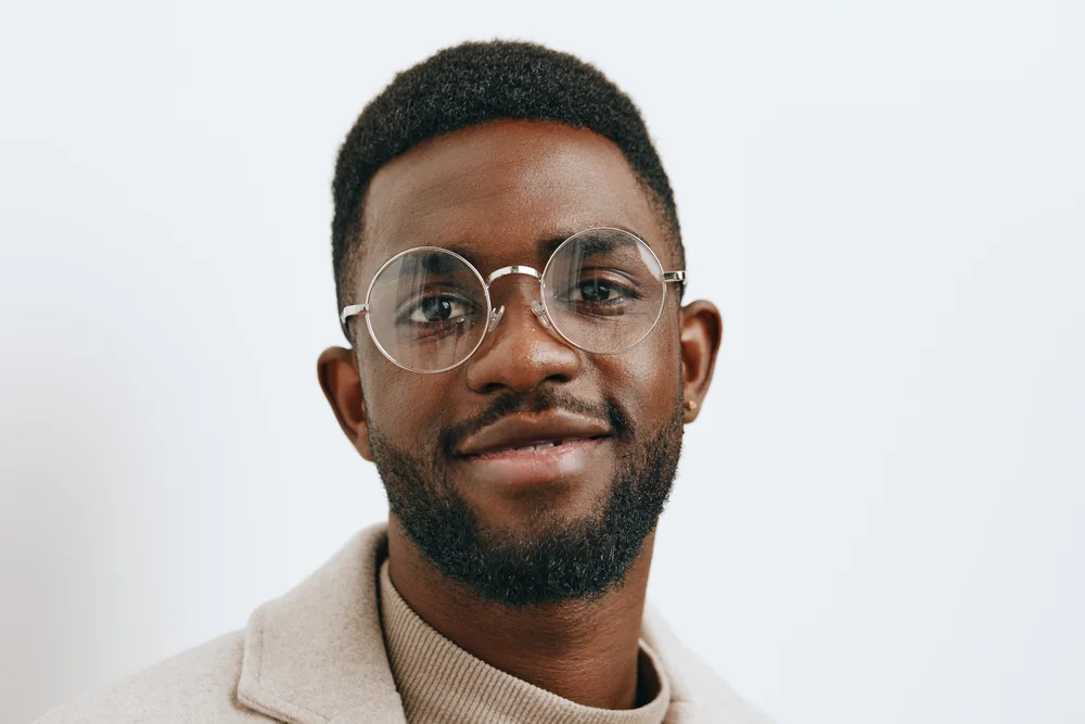 Retrato editorial de hombre con gafas y chaqueta beige