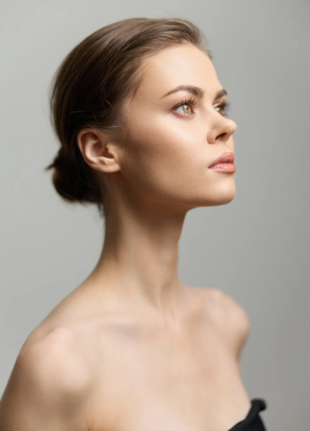 Retrato editorial de perfil con el cuello y el contorno facial visibles