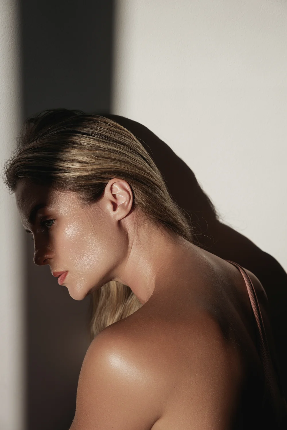 Retrato editorial de mujer con luz sobre el rostro y el hombro